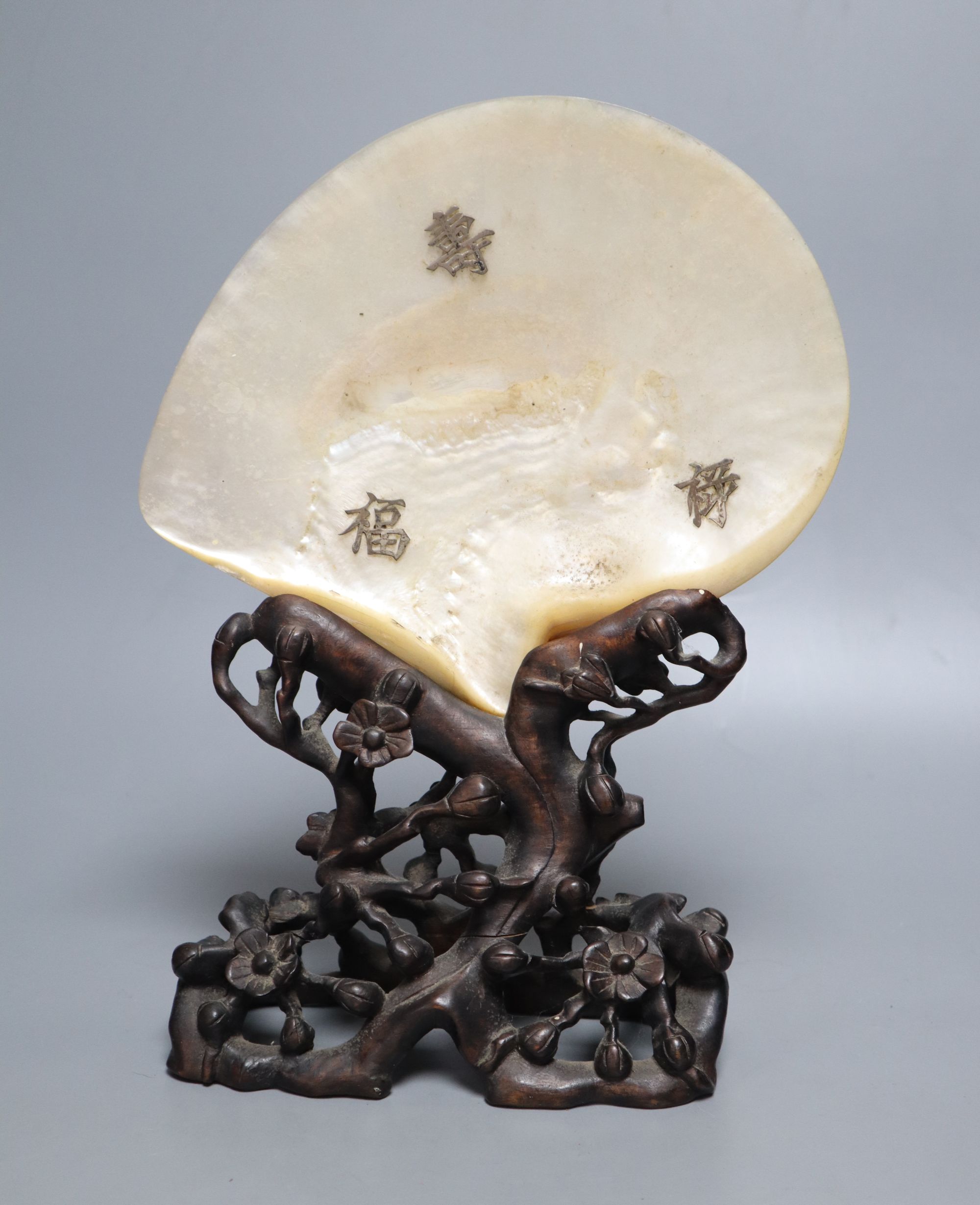 A Chinese mother of pearl shell on wood stand, c.1910